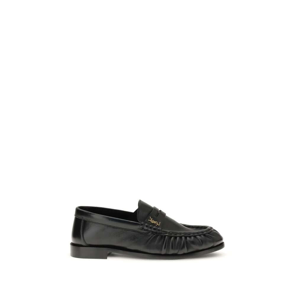 Black Lamb Ovis Aries Aries Slip-On LoafersLe Loafer Loafers by Saint Laurent combine classic elegance and iconic details. Crafted from supple leather, they feature a hand-stitched moc toe and the signature CASSANDRE embellishment in gold-tone metal. The