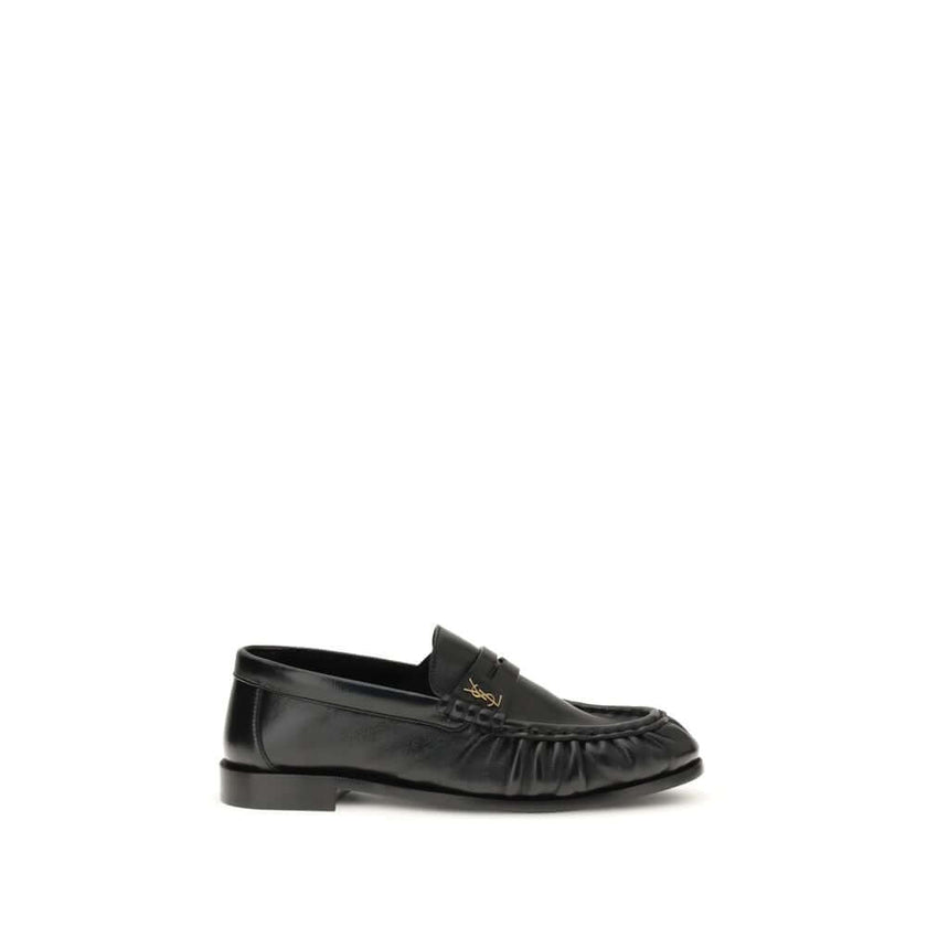 Black Lamb Ovis Aries Aries Slip-On LoafersLe Loafer Loafers by Saint Laurent combine classic elegance and iconic details. Crafted from supple leather, they feature a hand-stitched moc toe and the signature CASSANDRE embellishment in gold-tone metal. The