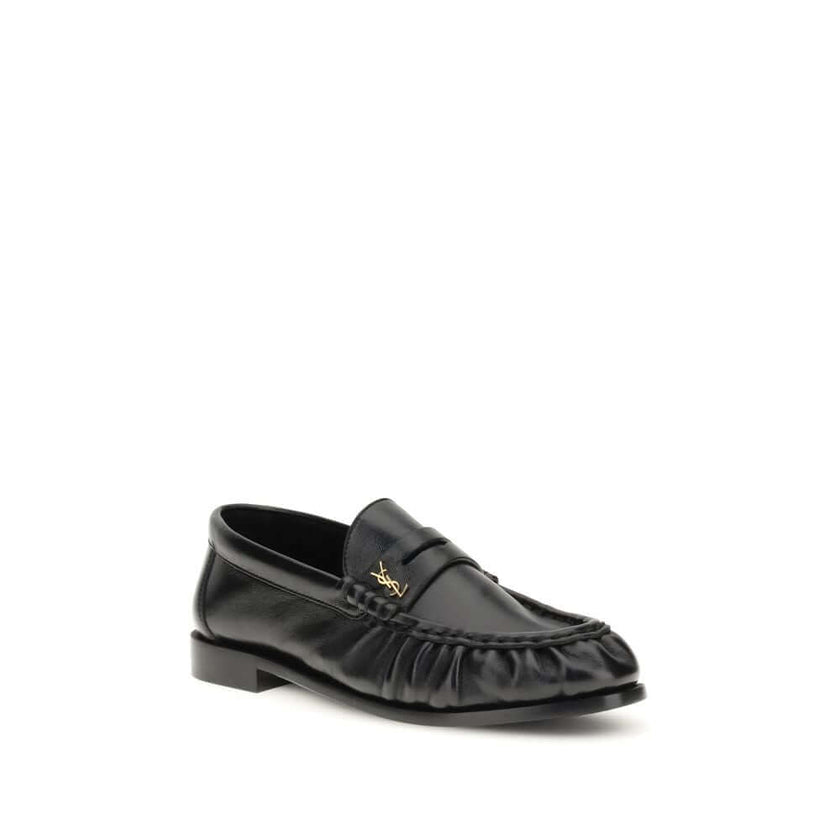 Black Lamb Ovis Aries Aries Slip-On LoafersLe Loafer Loafers by Saint Laurent combine classic elegance and iconic details. Crafted from supple leather, they feature a hand-stitched moc toe and the signature CASSANDRE embellishment in gold-tone metal. The