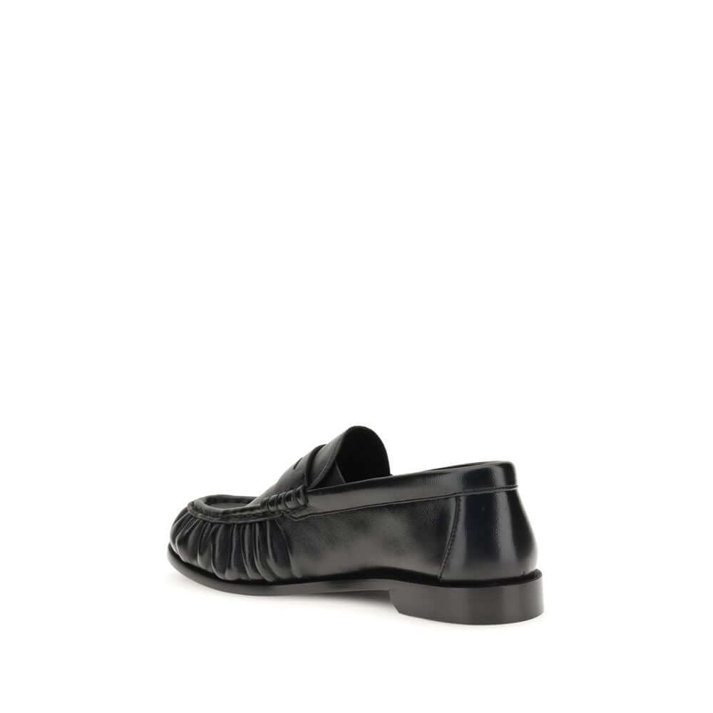 Black Lamb Ovis Aries Aries Slip-On LoafersLe Loafer Loafers by Saint Laurent combine classic elegance and iconic details. Crafted from supple leather, they feature a hand-stitched moc toe and the signature CASSANDRE embellishment in gold-tone metal. The