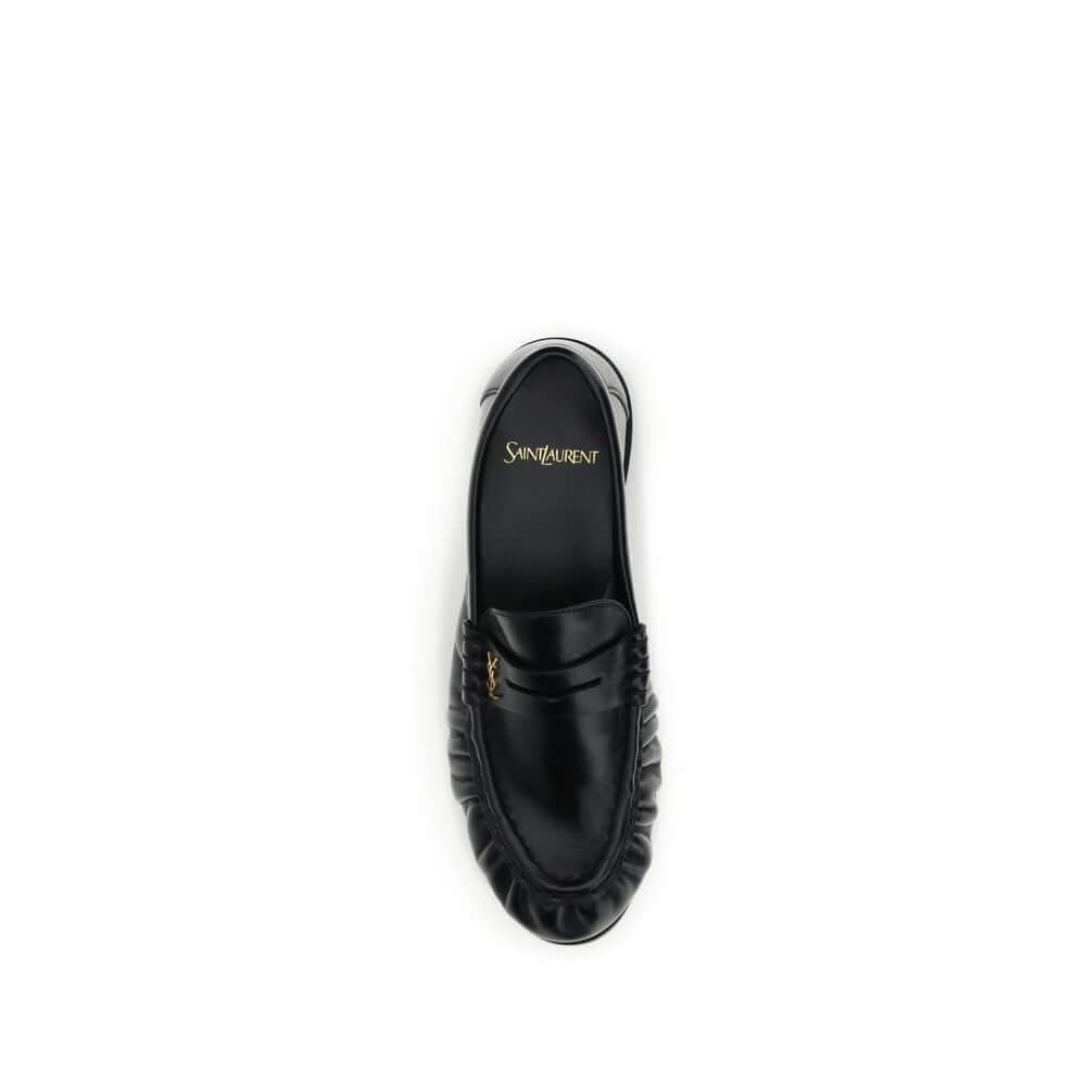 Black Lamb Ovis Aries Aries Slip-On LoafersLe Loafer Loafers by Saint Laurent combine classic elegance and iconic details. Crafted from supple leather, they feature a hand-stitched moc toe and the signature CASSANDRE embellishment in gold-tone metal. The