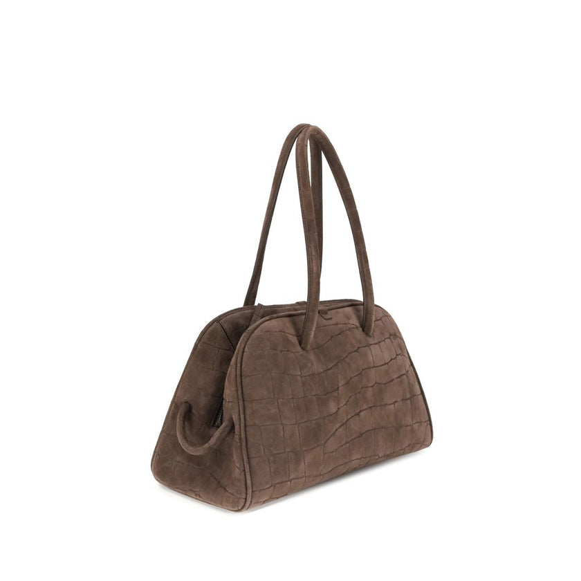 Il Turismo Shoulder BagThe Il Turismo Shoulder Bag by Jacquemus reinterprets the classic bowling bag with a contemporary twist. Crafted from crocodile-embossed suede, it features a two-way zip closure and matching tubular leather handles with a knotted de