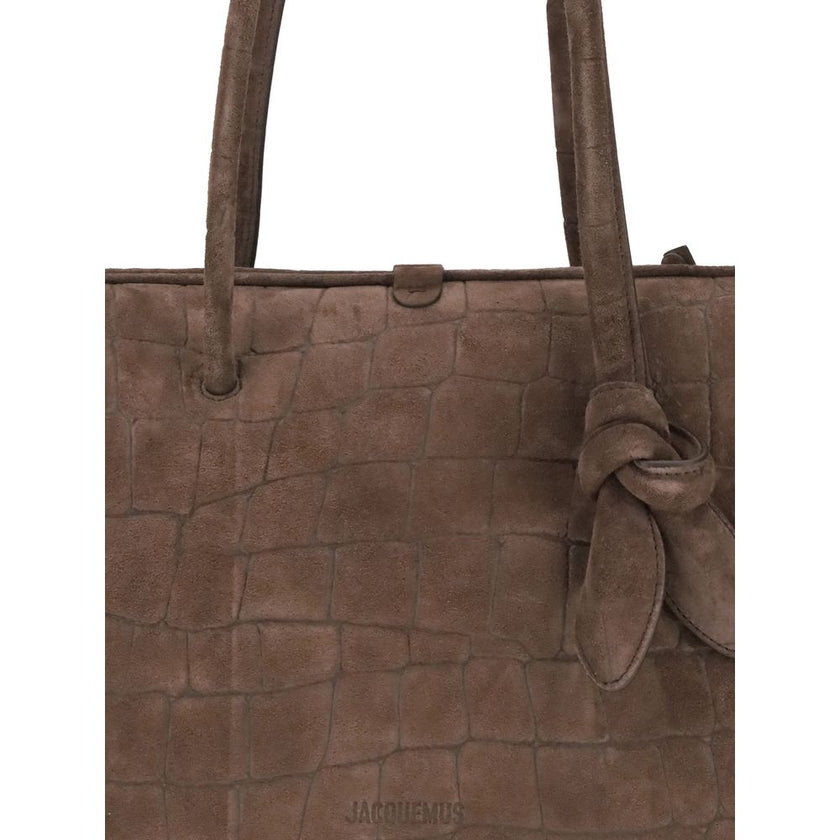 Il Turismo Shoulder BagThe Il Turismo Shoulder Bag by Jacquemus reinterprets the classic bowling bag with a contemporary twist. Crafted from crocodile-embossed suede, it features a two-way zip closure and matching tubular leather handles with a knotted de