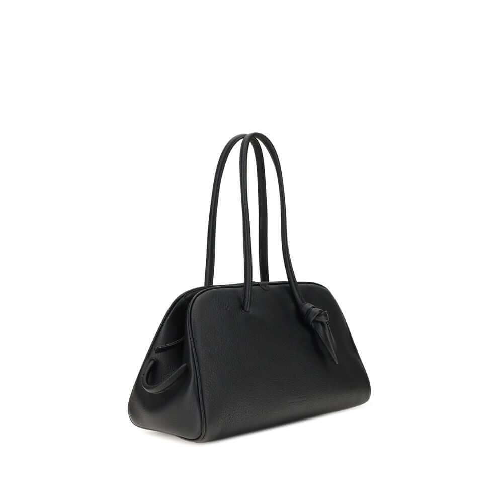 Black Calf Leather Bos Taurus HandbagThe Il Turismo Shoulder Bag by Jacquemus is an elegant reinterpretation of the classic bowling bag, crafted from grainy leather. Featuring a two-way zipper closure, it features a large patch pocket on the front, an int