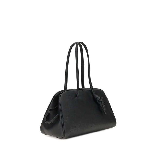 Black Calf Leather Bos Taurus HandbagThe Il Turismo Shoulder Bag by Jacquemus is an elegant reinterpretation of the classic bowling bag, crafted from grainy leather. Featuring a two-way zipper closure, it features a large patch pocket on the front, an int
