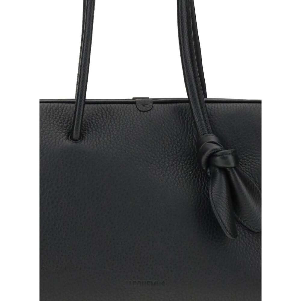 Black Calf Leather Bos Taurus HandbagThe Il Turismo Shoulder Bag by Jacquemus is an elegant reinterpretation of the classic bowling bag, crafted from grainy leather. Featuring a two-way zipper closure, it features a large patch pocket on the front, an int
