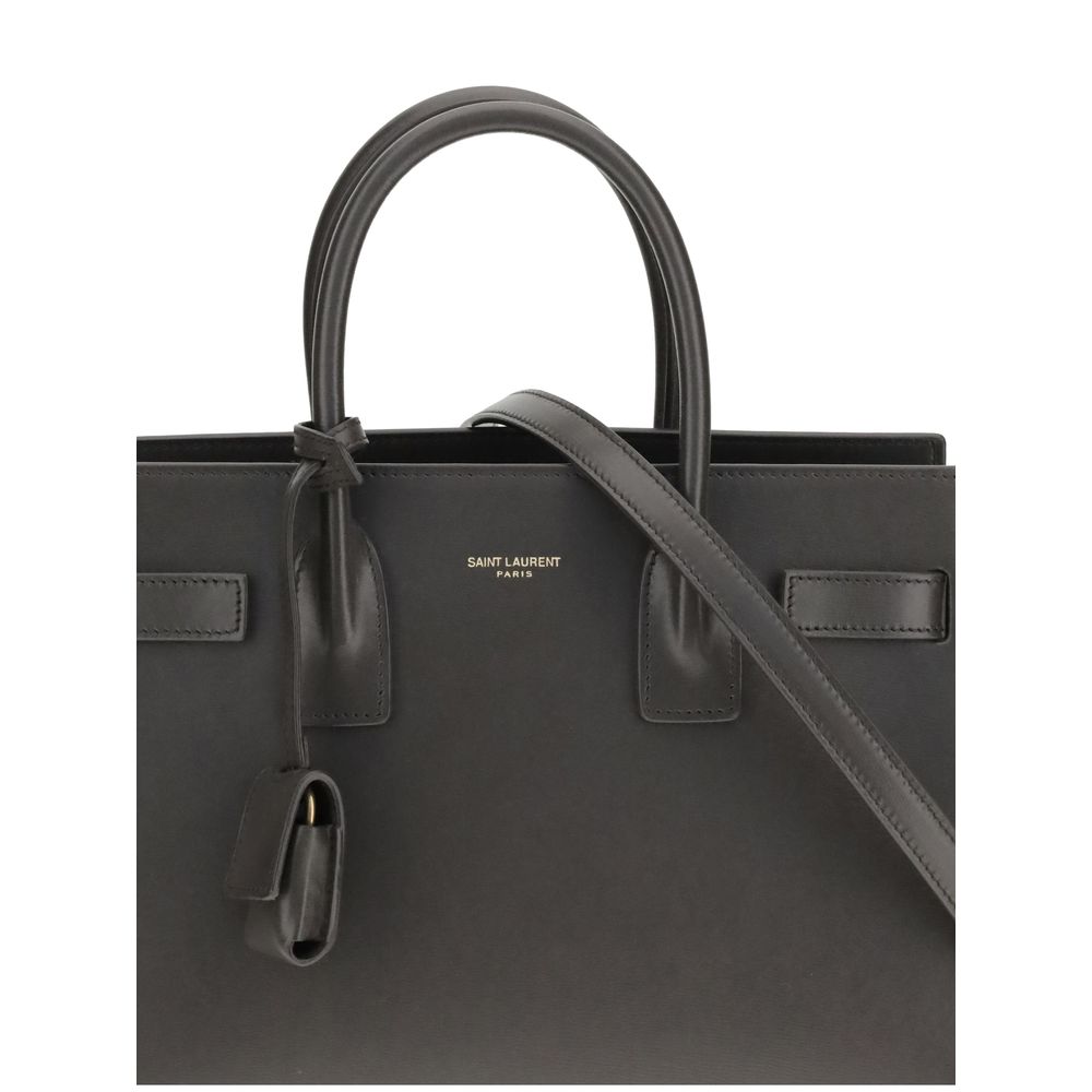 Gray Calf Leather Bos Taurus Shoulder BagThe Sac De Jour Baby leather Handbag by Saint Laurent is an iconic and elegant accessory, crafted from smooth leather and embellished with the brand’s monogram printed on the front. Featuring two round handles, an