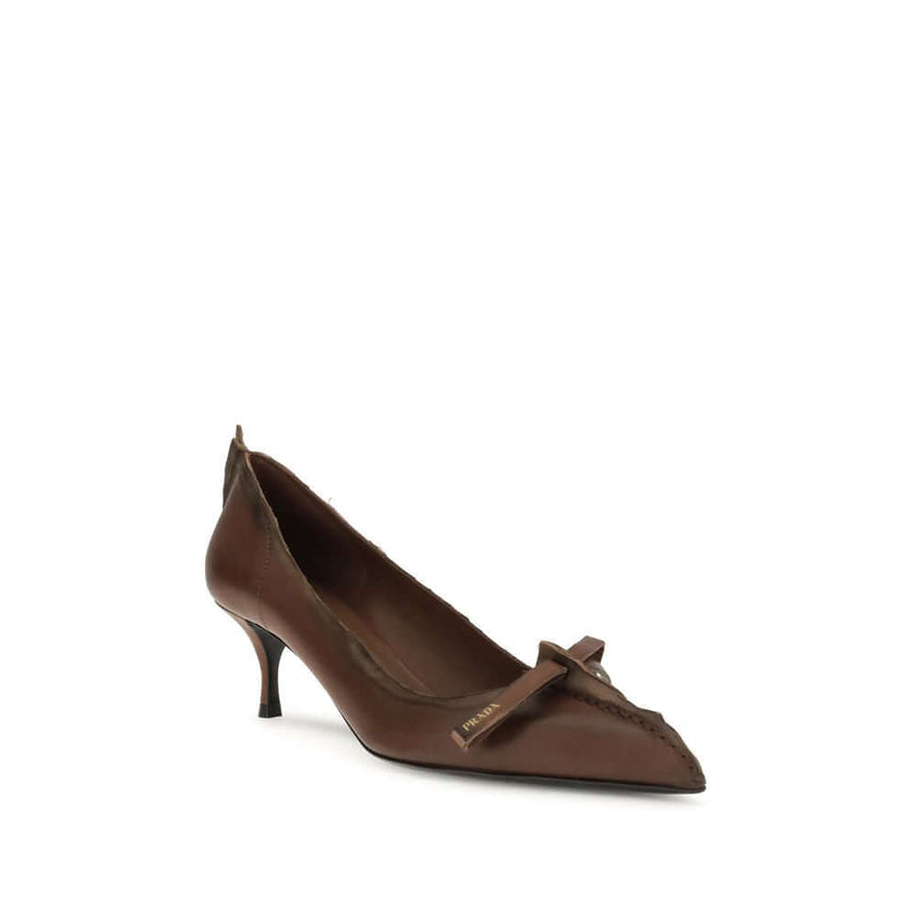 Antique leather PumpsAntique leather Pumps by Prada reinterpret a feminine classic with a bold, unconventional aesthetic. The tapered toe silhouette is crafted from leather with an antiqued effect, enhanced by exposed stitching and rough edges deliberatel