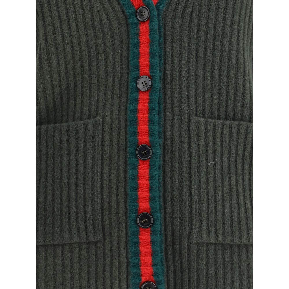 Green Wool Sleeveles SweaterThe Wool Cardigan Vest by Gucci revisits a knitwear essential with refined, contemporary appeal. Its V-neckline and ribbed construction highlight the quality of the yarn, while the contrasting trims add a sharp, graphic accent.