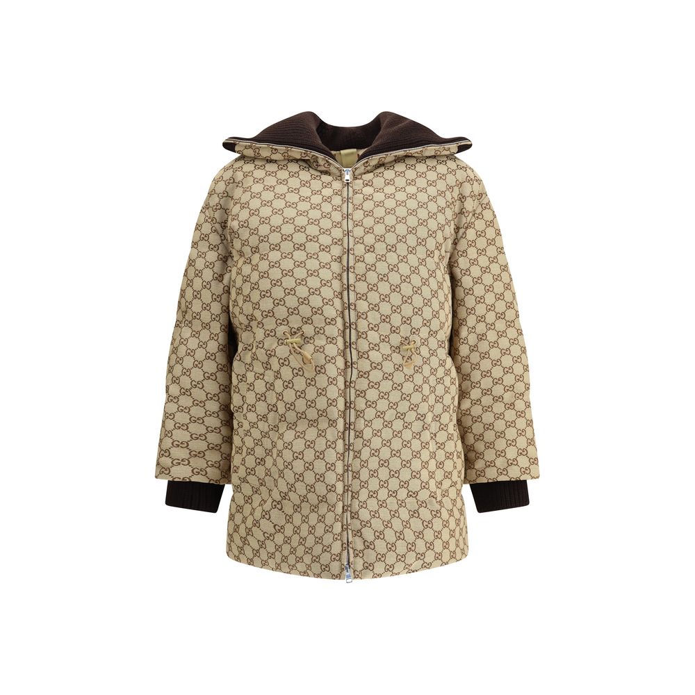 Beige Cotton BomberThe fabric Bomber Jacket by Gucci reinterprets the maison’s heritage through the GG motif in camel and ebony tones. Cut in a regular fit with dropped shoulders, the silhouette blends functionality and sophistication: a ribbed high colla