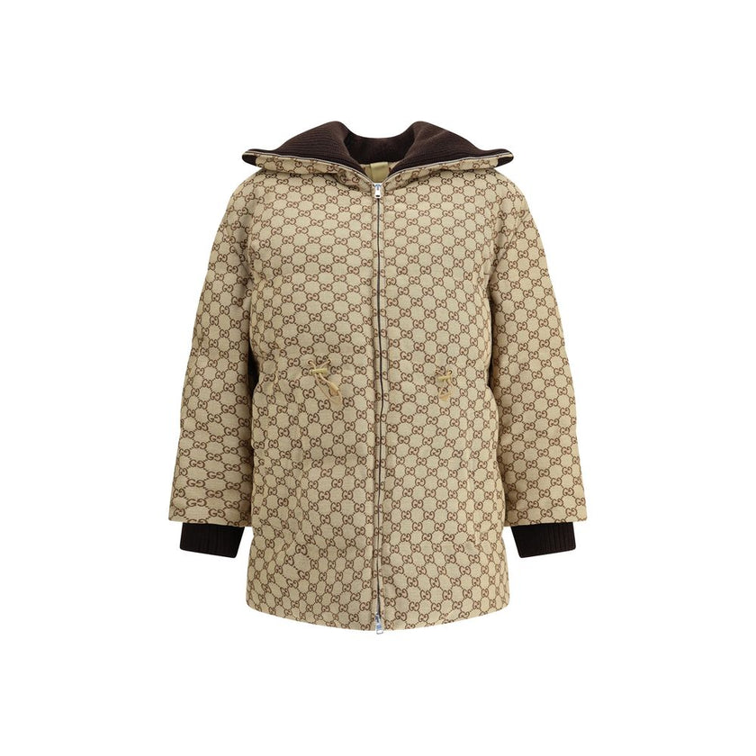 Beige Cotton BomberThe fabric Bomber Jacket by Gucci reinterprets the maison’s heritage through the GG motif in camel and ebony tones. Cut in a regular fit with dropped shoulders, the silhouette blends functionality and sophistication: a ribbed high colla