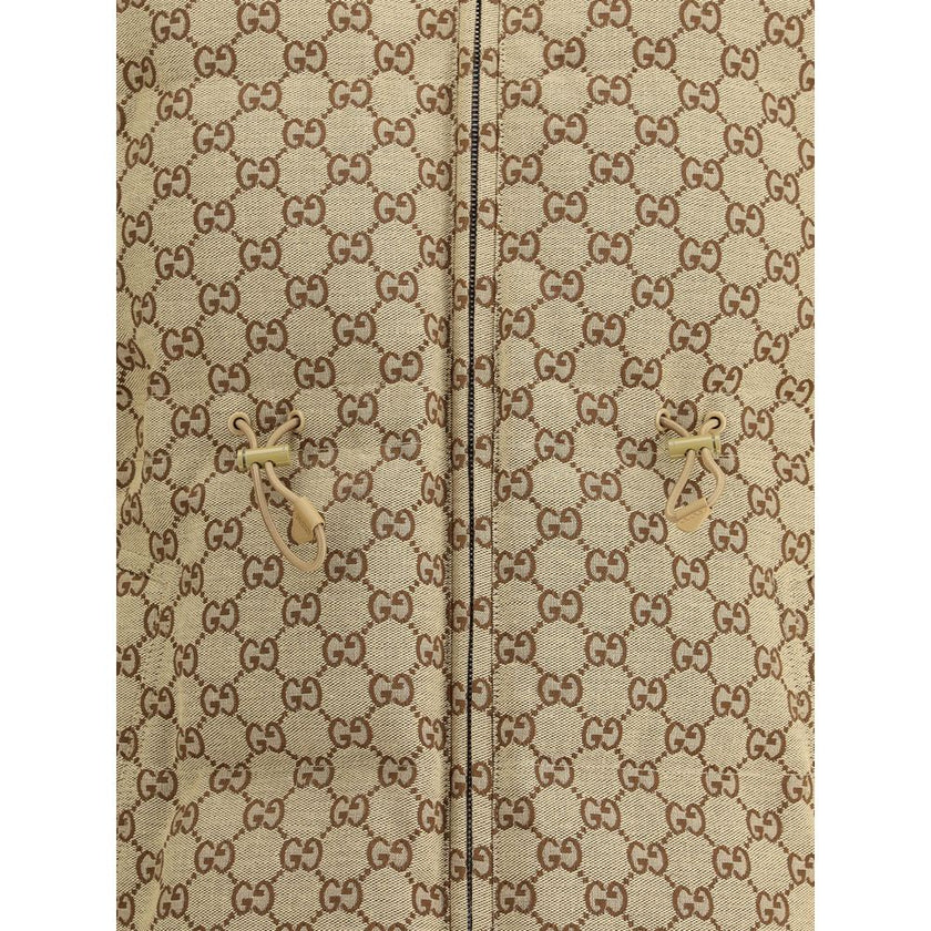 Beige Cotton BomberThe fabric Bomber Jacket by Gucci reinterprets the maison’s heritage through the GG motif in camel and ebony tones. Cut in a regular fit with dropped shoulders, the silhouette blends functionality and sophistication: a ribbed high colla