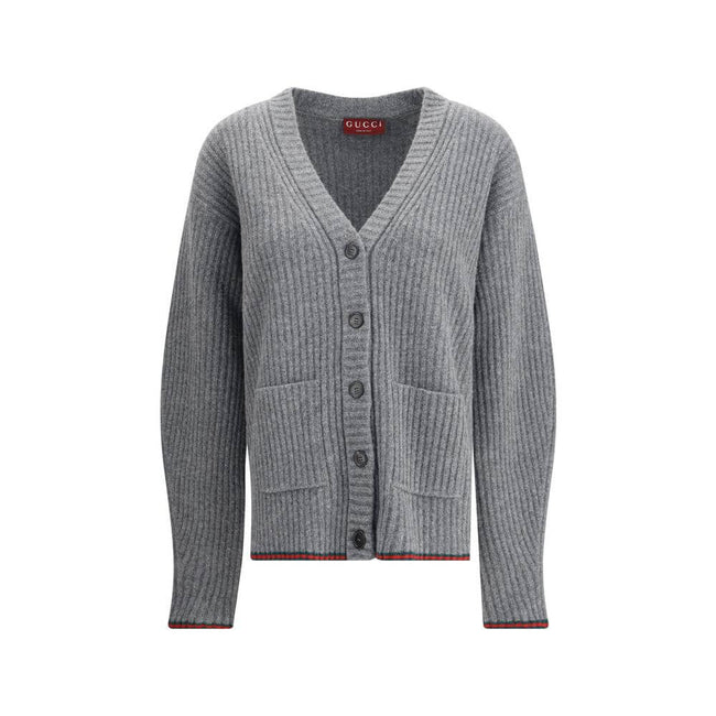 Gray Wool CardiganThe Wool Cardigan by Gucci embodies timeless elegance with its ribbed knit construction and refined V-neckline. Dropped shoulders and long sleeves create a relaxed silhouette, while the maison’s iconic green and red Web trim highlights t
