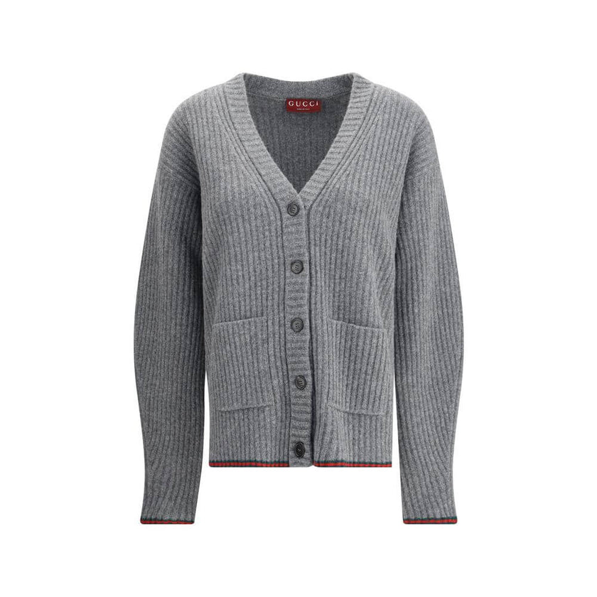 Gray Wool CardiganThe Wool Cardigan by Gucci embodies timeless elegance with its ribbed knit construction and refined V-neckline. Dropped shoulders and long sleeves create a relaxed silhouette, while the maison’s iconic green and red Web trim highlights t