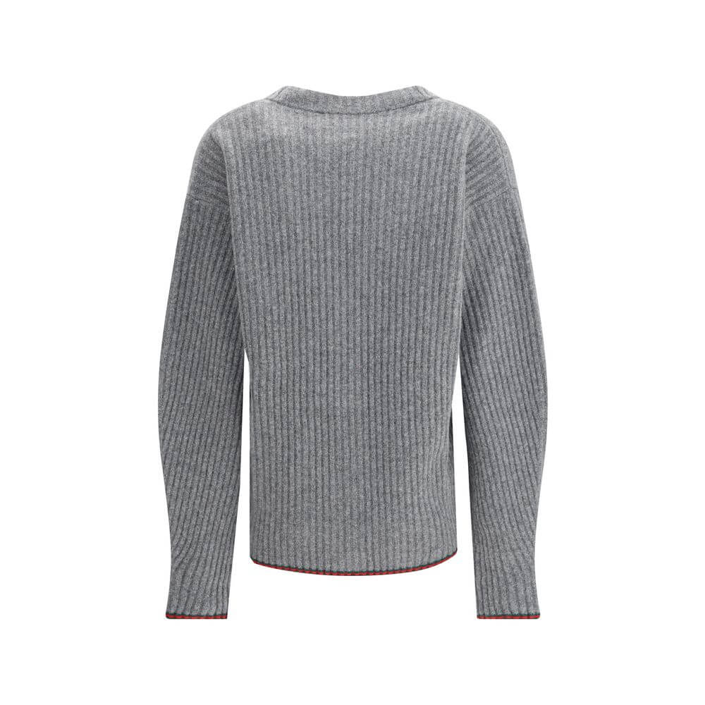 Gray Wool CardiganThe Wool Cardigan by Gucci embodies timeless elegance with its ribbed knit construction and refined V-neckline. Dropped shoulders and long sleeves create a relaxed silhouette, while the maison’s iconic green and red Web trim highlights t
