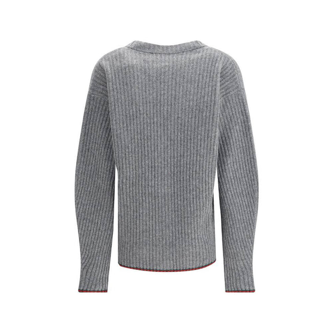 Gray Wool CardiganThe Wool Cardigan by Gucci embodies timeless elegance with its ribbed knit construction and refined V-neckline. Dropped shoulders and long sleeves create a relaxed silhouette, while the maison’s iconic green and red Web trim highlights t