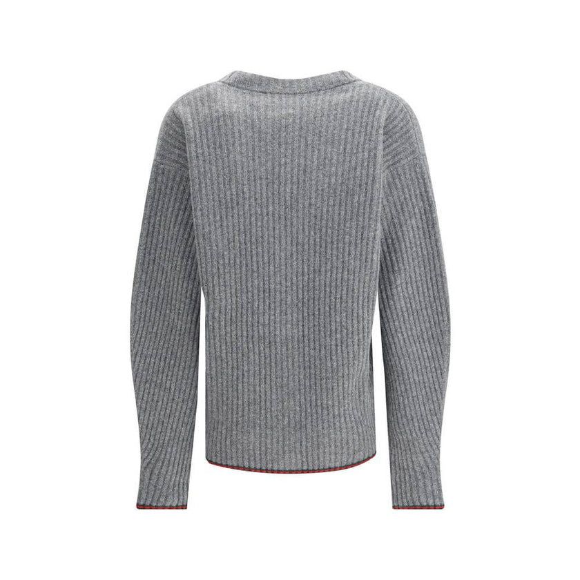 Gray Wool CardiganThe Wool Cardigan by Gucci embodies timeless elegance with its ribbed knit construction and refined V-neckline. Dropped shoulders and long sleeves create a relaxed silhouette, while the maison’s iconic green and red Web trim highlights t