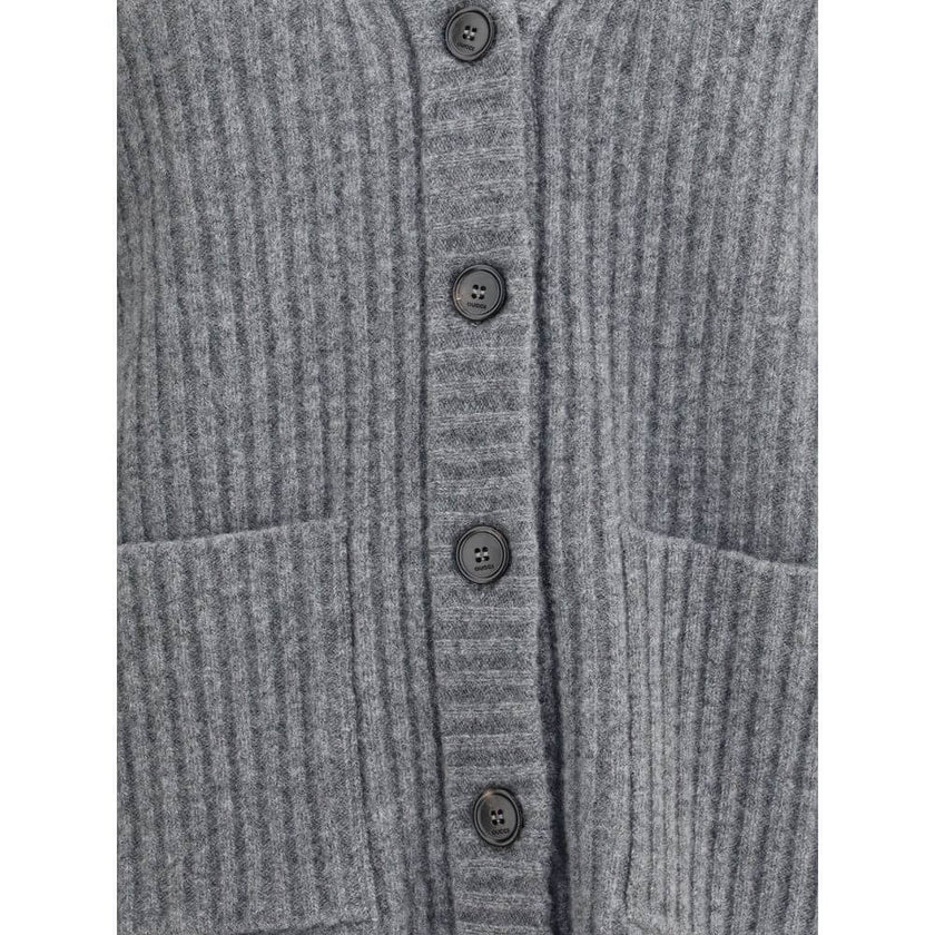 Gray Wool CardiganThe Wool Cardigan by Gucci embodies timeless elegance with its ribbed knit construction and refined V-neckline. Dropped shoulders and long sleeves create a relaxed silhouette, while the maison’s iconic green and red Web trim highlights t