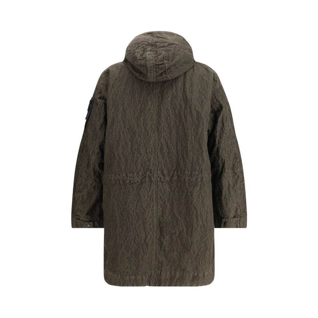 Green Cotton CoatThe wrinkled Corduroy Coat by Stone Island embodies the brand’s commitment to fabric innovation and functional design. Crafted from textured corduroy with a distinctive crinkled effect, it features a dual closure with zip and buttons, two