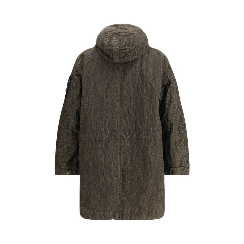 Green Cotton CoatThe wrinkled Corduroy Coat by Stone Island embodies the brand’s commitment to fabric innovation and functional design. Crafted from textured corduroy with a distinctive crinkled effect, it features a dual closure with zip and buttons, two