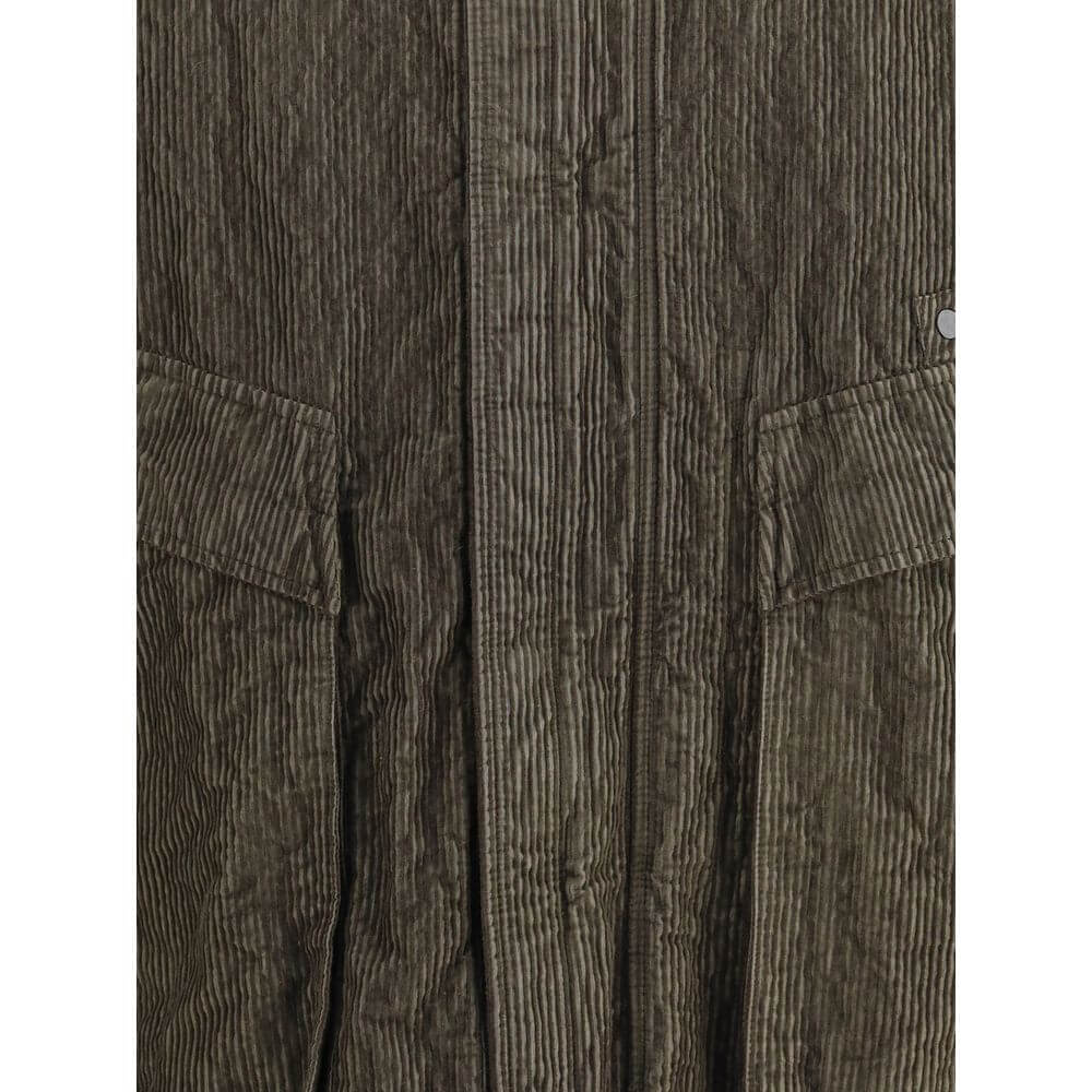Green Cotton CoatThe wrinkled Corduroy Coat by Stone Island embodies the brand’s commitment to fabric innovation and functional design. Crafted from textured corduroy with a distinctive crinkled effect, it features a dual closure with zip and buttons, two