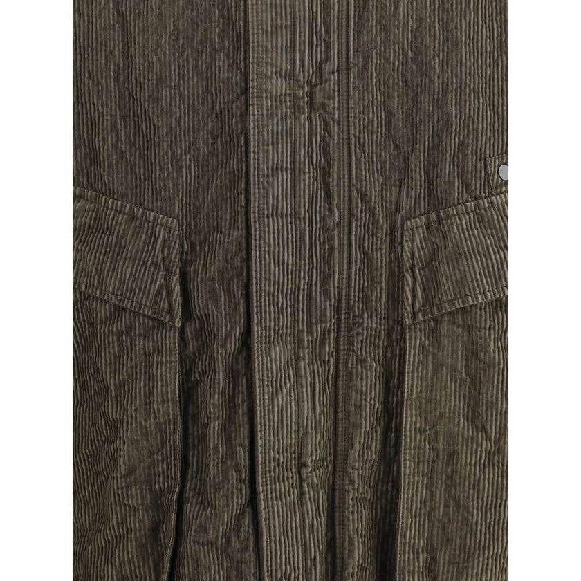 Green Cotton CoatThe wrinkled Corduroy Coat by Stone Island embodies the brand’s commitment to fabric innovation and functional design. Crafted from textured corduroy with a distinctive crinkled effect, it features a dual closure with zip and buttons, two