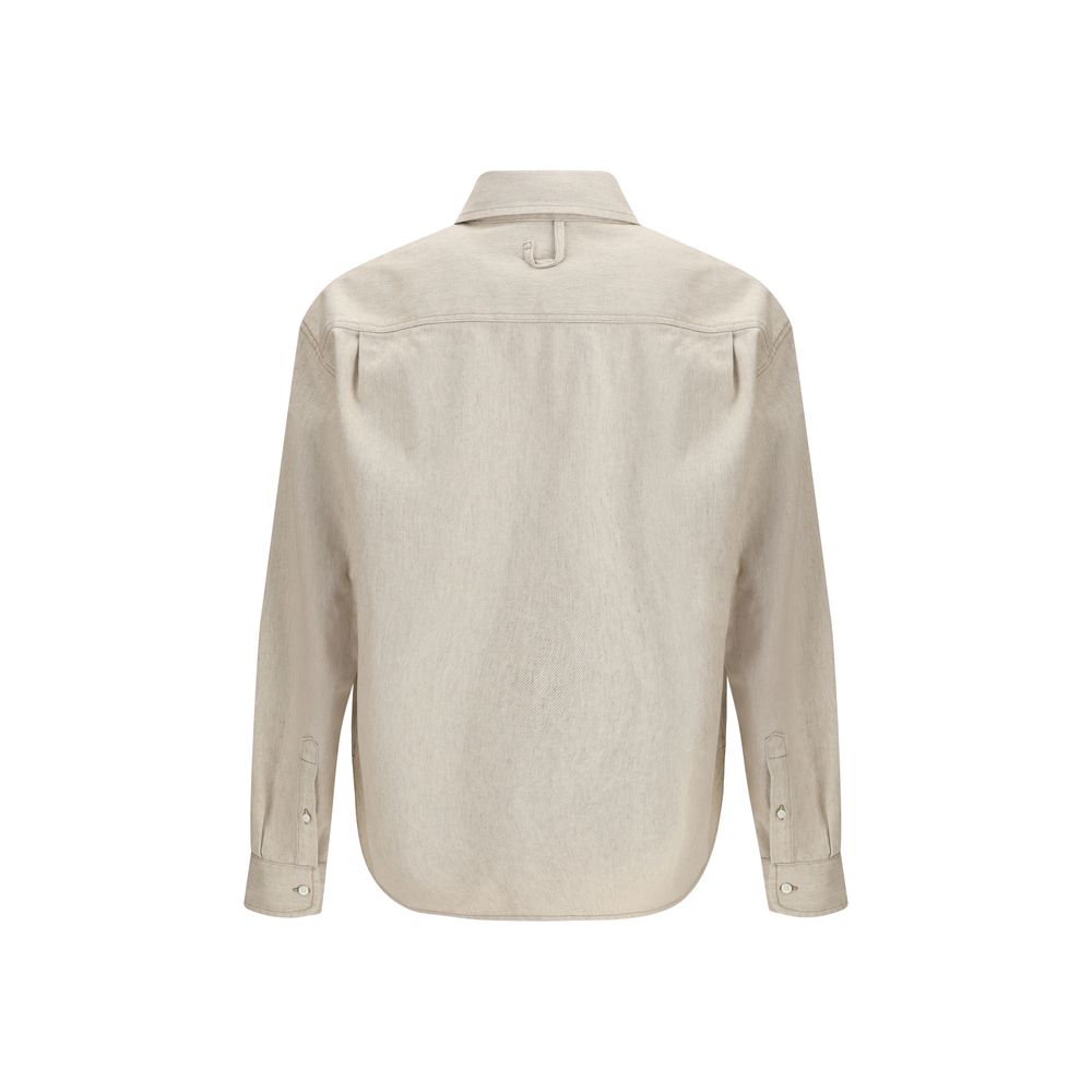 Beige Denim ShirtThe Simon denim Shirt in de-Nîmes by Jacquemus reinterprets a wardrobe classic with the Maison’s refined, contemporary spirit. Crafted from soft cotton and hemp denim, it features a straight fit that falls naturally along the body. A poin