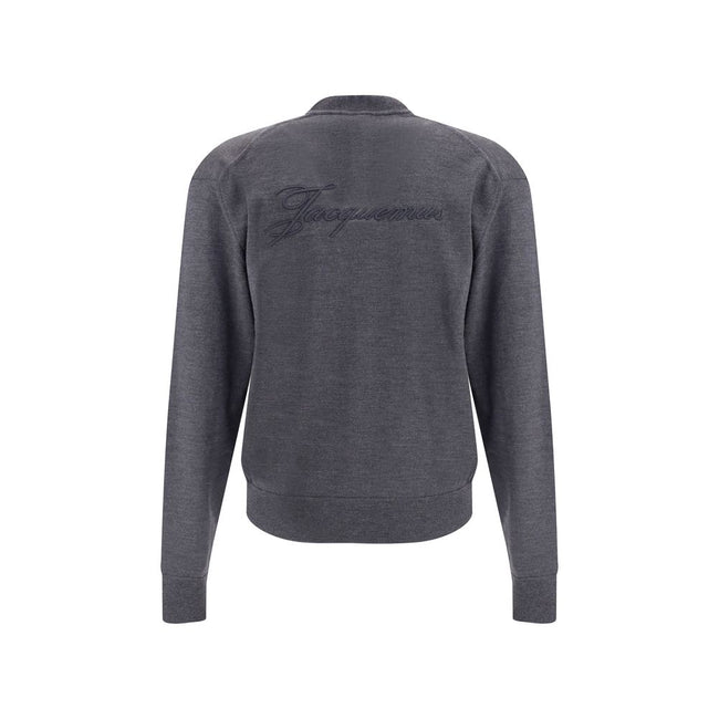 Gray Merino Wool CardiganThe merino Wool Cardigan by Jacquemus blends elegance with comfort, embodying a timeless appeal. Its V-neckline and front button closure echo classic tailoring, while ribbed hem and cuffs provide structure and refinement. At the b