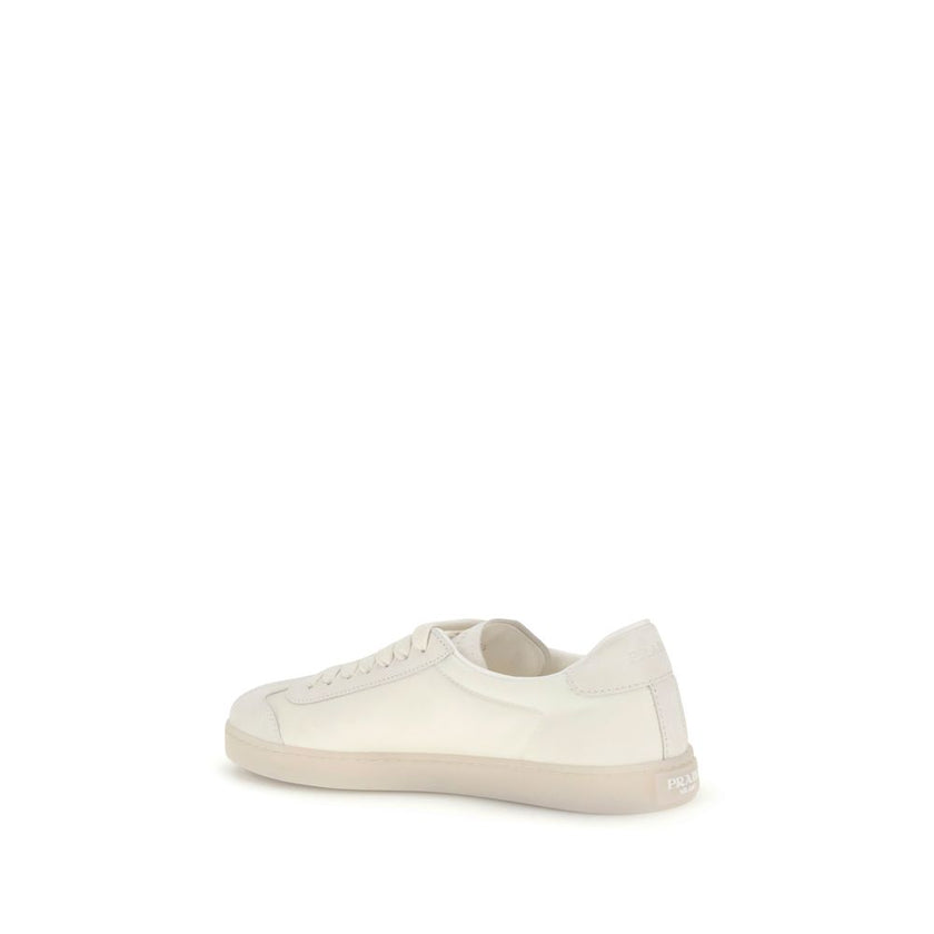 Cream Leather Low Top SneakersLeather Sneakers by Prada combine contemporary style with everyday comfort. Featuring a flat rubber sole and round toe, they are distinguished by the iconic triangular side-applied plaque and tone-on-tone logo on the back, ad