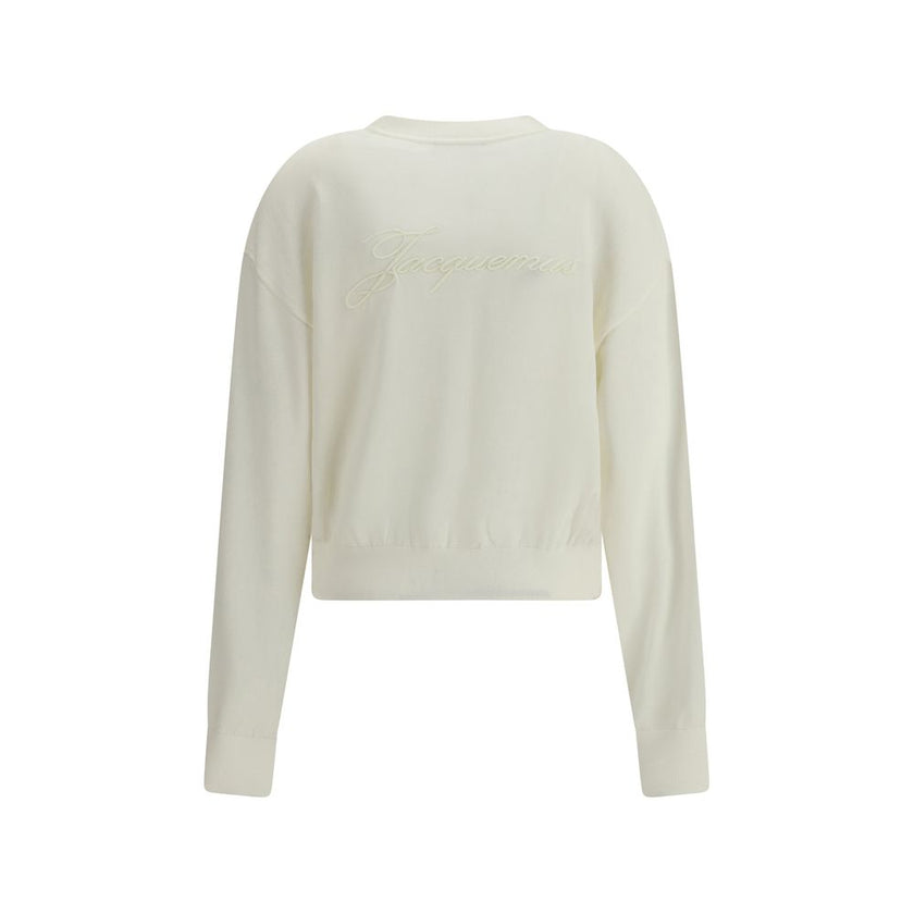 White Merino Wool CardiganMerino wool Cardigan by Jacquemus combines elegance and comfort with a V-neckline and front button closure. Finished with a ribbed hem and cuffs, it is embellished with an embroidered logo on the back for a distinctive, modern to