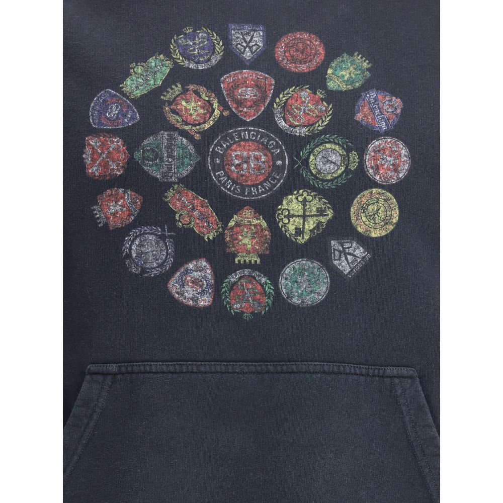 Black Cotton SweatshirtThe Spiral Crest Hoodie by Balenciaga in dry fleece redefines streetwear with a bold graphic accent. Designed with a medium fit, it features a hood without drawstrings, relaxed shoulders, and a front kangaroo pocket. The gathered cu