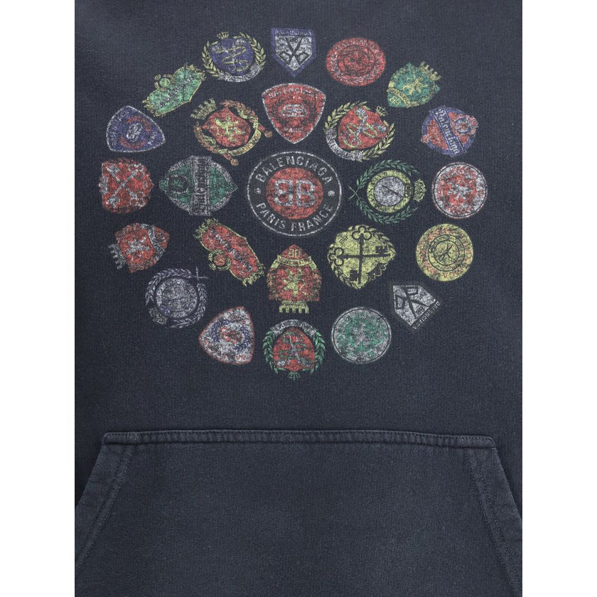 Black Cotton SweatshirtThe Spiral Crest Hoodie by Balenciaga in dry fleece redefines streetwear with a bold graphic accent. Designed with a medium fit, it features a hood without drawstrings, relaxed shoulders, and a front kangaroo pocket. The gathered cu