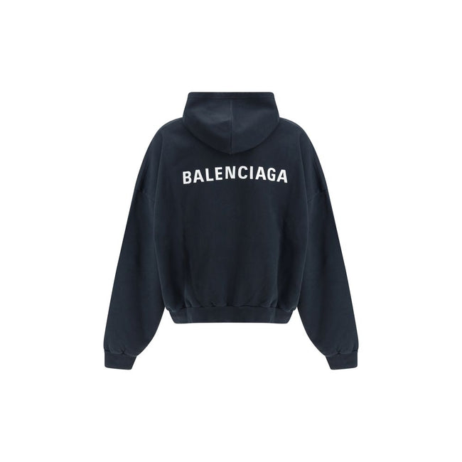 Black Cotton SweatshirtThe Hoodie by Balenciaga blends comfort with iconic design. Crafted from medium fleece, it features a relaxed silhouette with dropped shoulders and a functional kangaroo pocket. Elasticated cuffs and hem ensure a defined fit, while