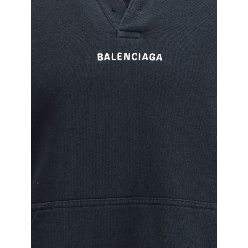 Black Cotton SweatshirtThe Hoodie by Balenciaga blends comfort with iconic design. Crafted from medium fleece, it features a relaxed silhouette with dropped shoulders and a functional kangaroo pocket. Elasticated cuffs and hem ensure a defined fit, while