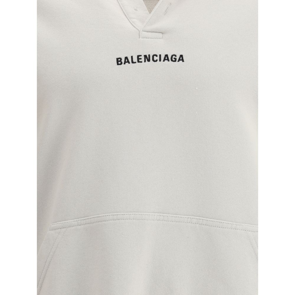 White Cotton SweatshirtThe Hoodie by Balenciaga blends comfort with iconic design. Crafted from medium fleece, it features a relaxed silhouette with dropped shoulders and a functional kangaroo pocket. Elasticated cuffs and hem ensure a defined fit, while