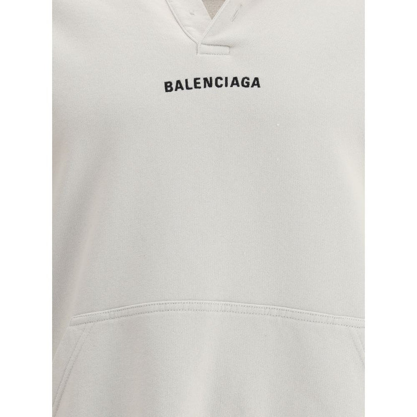 White Cotton SweatshirtThe Hoodie by Balenciaga blends comfort with iconic design. Crafted from medium fleece, it features a relaxed silhouette with dropped shoulders and a functional kangaroo pocket. Elasticated cuffs and hem ensure a defined fit, while