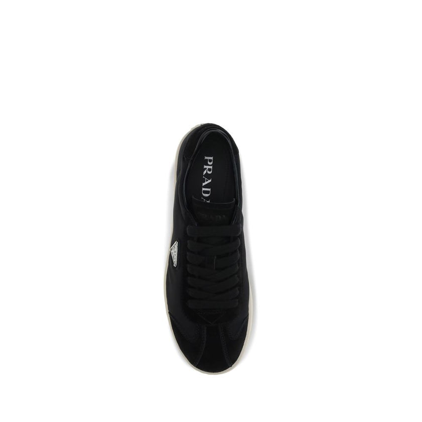 Black Leather Low Top SneakersLeather Sneakers by Prada combine contemporary style with everyday comfort. Featuring a flat rubber sole and round toe, they are distinguished by the iconic triangular side-applied plaque and tone-on-tone logo on the back, ad