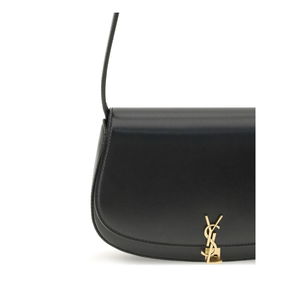 Black Calf Leather Bos Taurus Shoulder BagThe Voltaire mini Shoulder Bag by Saint Laurent is an elegant crescent-shaped bag crafted from calfskin with a lightly polished finish. Bronze-colored metallic parts add a warm, vintage touch, while the Cassandre