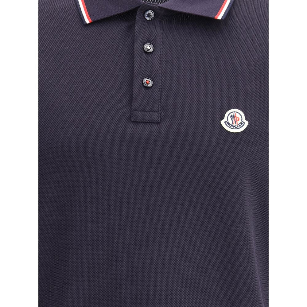 Polo shirtThe cotton piqué polo shirt by Moncler is a timeless classic that deserves a place in every wardrobe. Crafted from organic cotton, it combines comfort and sustainability with a clean, versatile style. The tricolor knit collar and cuffs add a dis