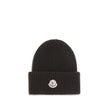 Black Wool BeanieThe beanie Hat by Moncler is crafted from a wool and cashmere blend with a brioche stitch that enhances its softness and style. The heavy knit ensures warmth and comfort, while the iconic felt patch on the front adds a distinctive and rec