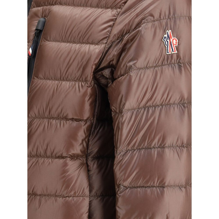 Brown Polyamide CoatThe Hers Jacket by Moncler Grenoble is a lightweight and functional piece designed to provide protection and practicality for any outdoor activity. Made from technical nylon, it features a high collar and a double-slider front zip with