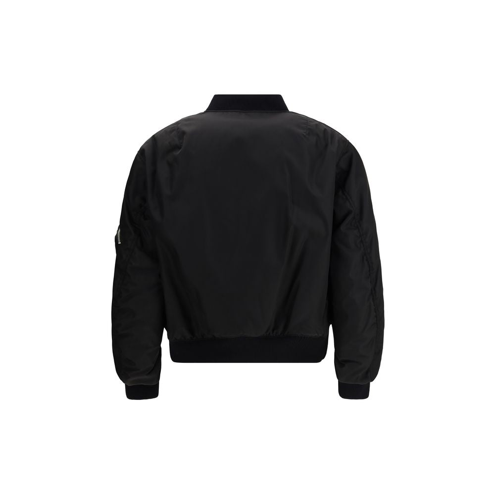 Black Polyamide BomberThe Prada Re-Nylon Bomber redefines a timeless silhouette with the house’s innovative sustainable fabric. Featuring a front zip closure, long sleeves with a classic utility-style zip pocket, and two side flap pockets, it combines fun