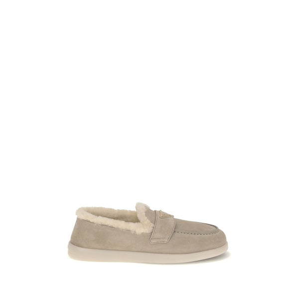 Beige Leather Slip-On LoafersSuede and sheepskin Loafers by Prada combine elegance and comfort in a modern, streamlined silhouette. The upper is embellished with a leather horsebit and a pinch-stitched basin, hallmarks of painstaking craftsmanship. The sh
