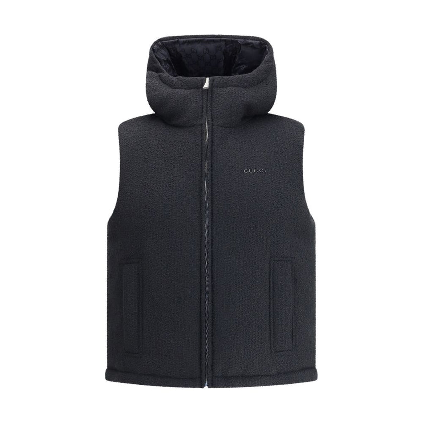 Black Wool Sleveless JacketThe Reversible Bouclé Wool Gilet by Gucci fuses practicality with contemporary elegance. One side showcases the rich texture of black bouclé wool, while the other reveals nylon detailed with the iconic GG motif, offering two dis