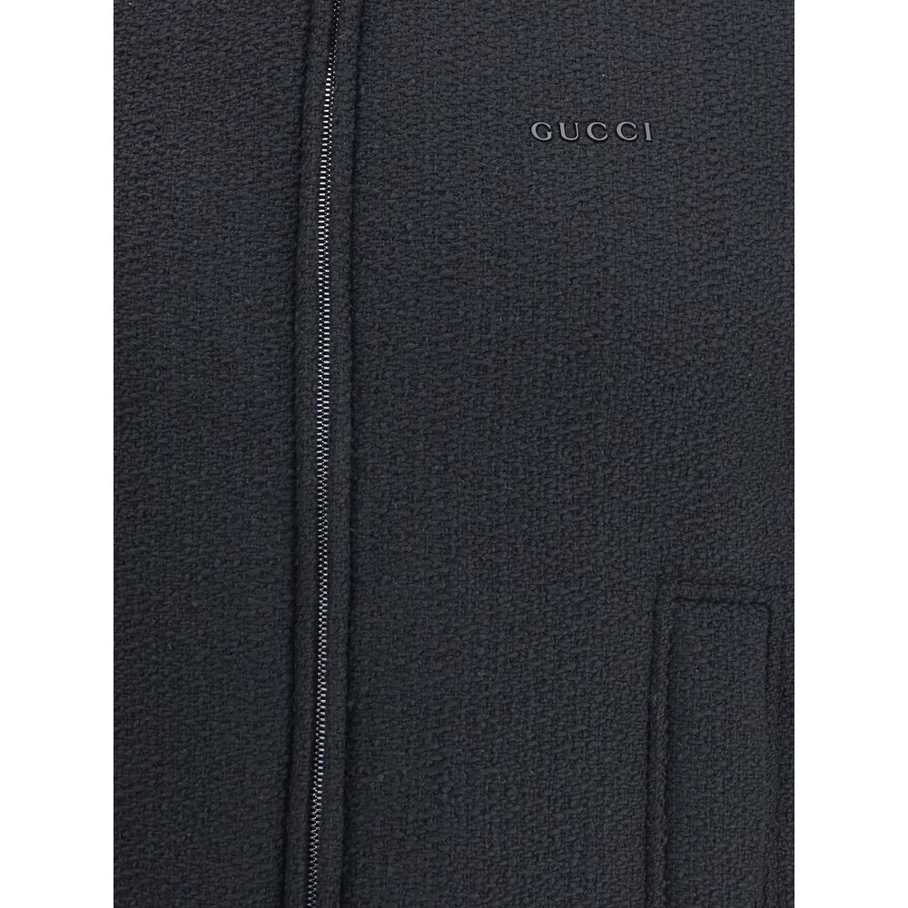 Black Wool Sleveless JacketThe Reversible Bouclé Wool Gilet by Gucci fuses practicality with contemporary elegance. One side showcases the rich texture of black bouclé wool, while the other reveals nylon detailed with the iconic GG motif, offering two dis
