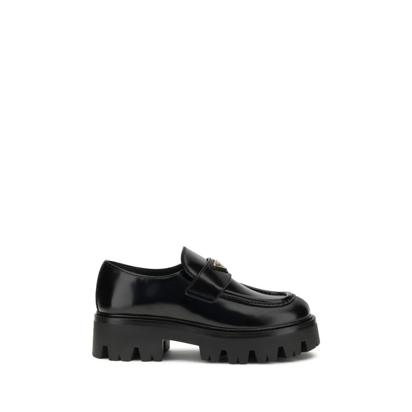 Black Calf Leather Bos Taurus Platform LoafersBrushed leather Monolith Loafers by Prada reinterpret a classic with a bold, contemporary twist. Featuring a leather horsebit upper with metallic detail, they have a burlotto bowl and an all-leather lining. Th
