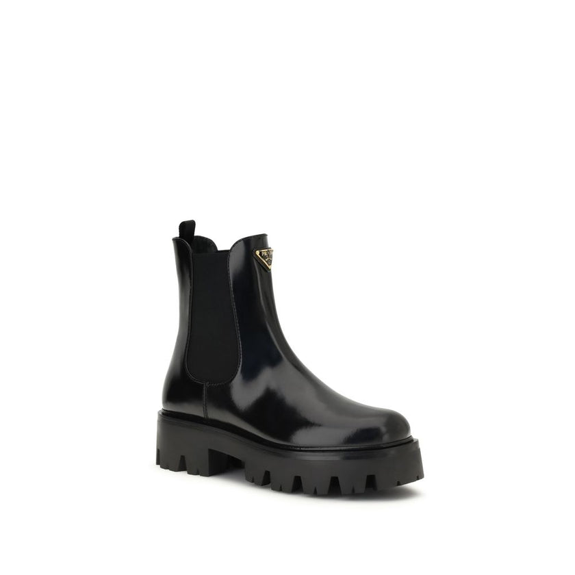 Black Rubber Ankle BootsThe brushed leather Ankle Boots by Prada combine sophistication with bold character. The upper features elasticated side inserts and a rear pull tab, while the leather lining ensures comfort and artisanal quality. The iconic enamel