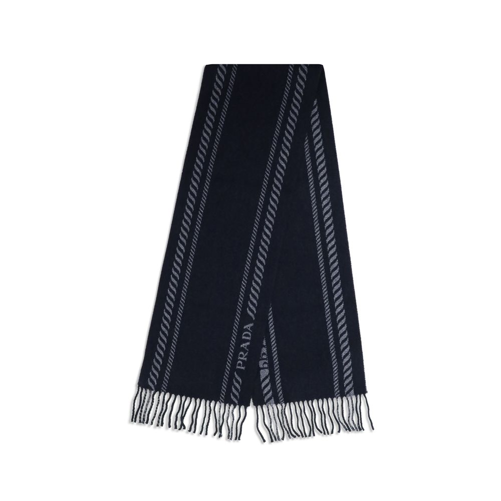 Blue Fleece Wool ScarfThe virgin wool and cashmere Scarf by Prada is an elegant and versatile accessory. Crafted from soft blue virgin wool and cashmere, it is enriched with a refined grey striped pattern and logo inlay along the edges. Fringed hems add a