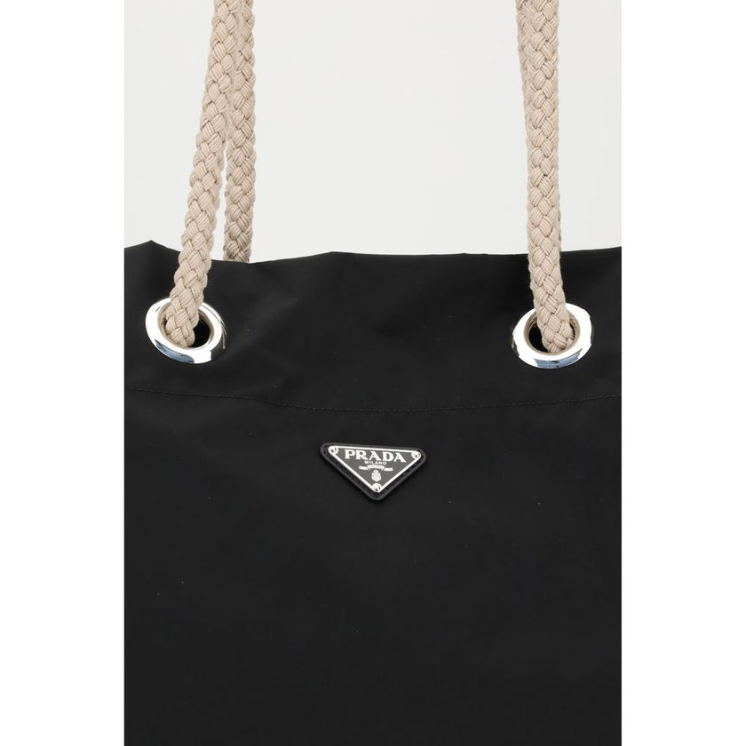 Black Recycled Polyamide Shoulder BagMedium Mariner Re-Nylon Bucket Bag by Prada combines functional design and sustainable materials. The soft, roomy silhouette is enhanced by rope and leather sliding handles that contrast with the technical texture of R