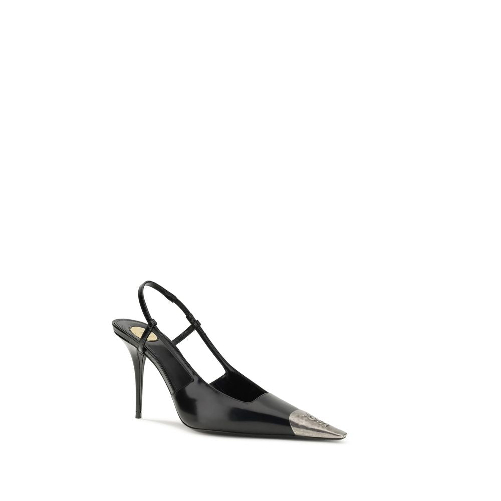 Black Calf Leather Bos Taurus PumpsJeanne Pumps by Saint Laurent are distinguished by a square metal toe decorated with a hammered Cassandre motif, which lends a bold and sophisticated touch. The opening at the back is enhanced by the elasticized strap, w